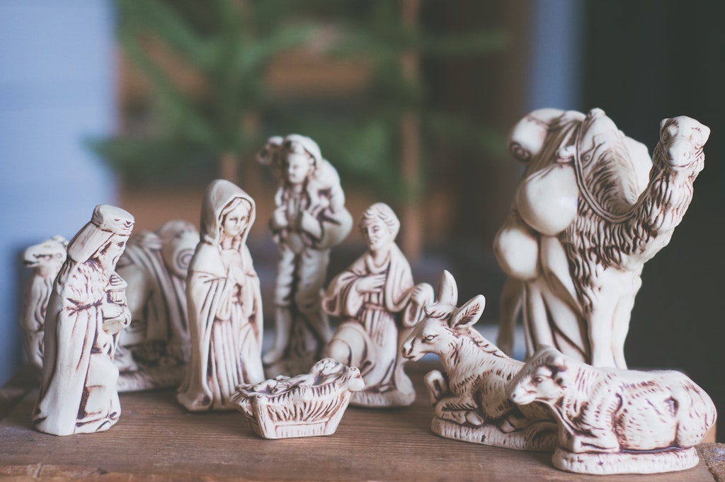 Ox and ass kneeling at crib
