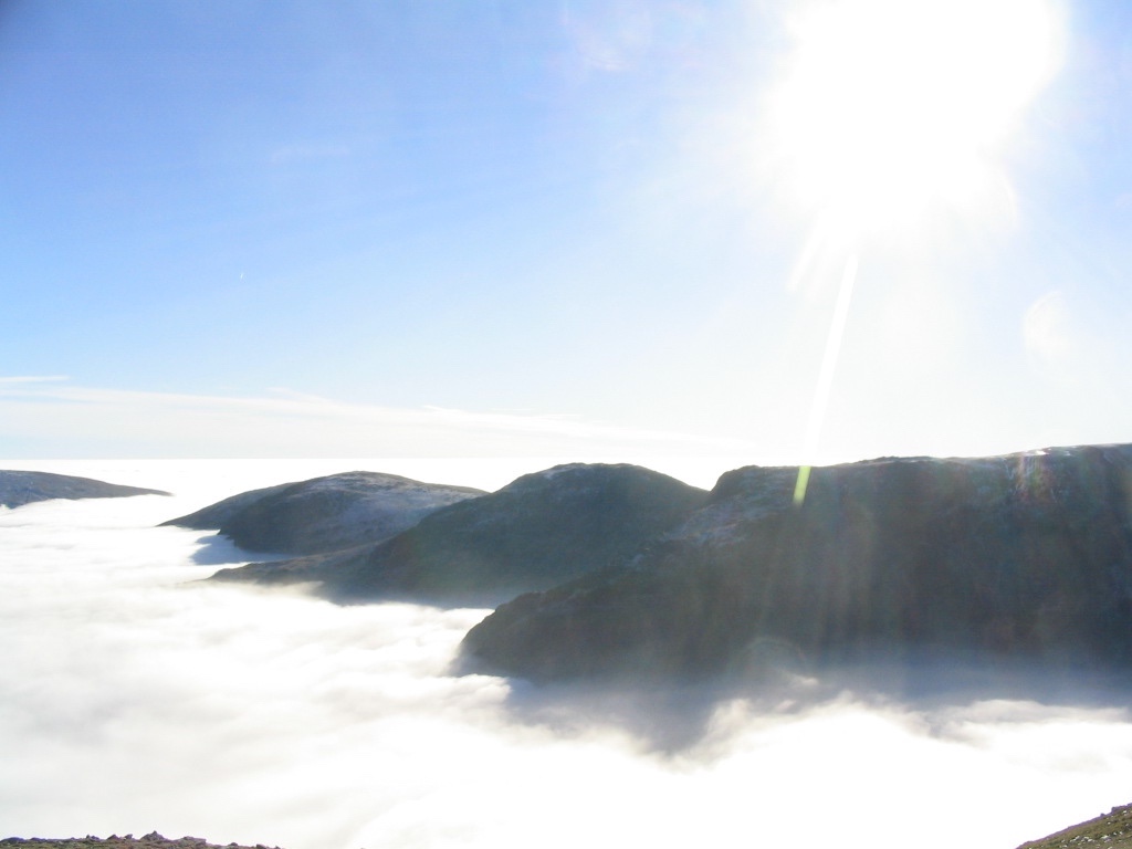 Sun shining in glory above white clouds
