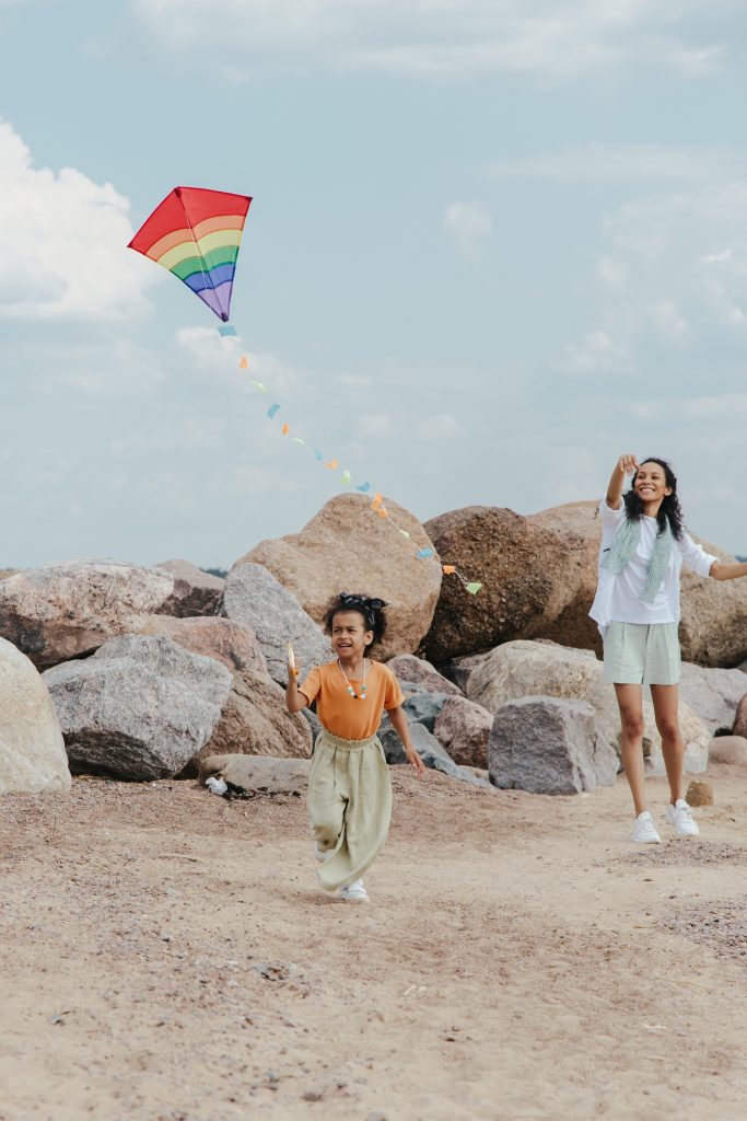 Child plays with kite on the beach
