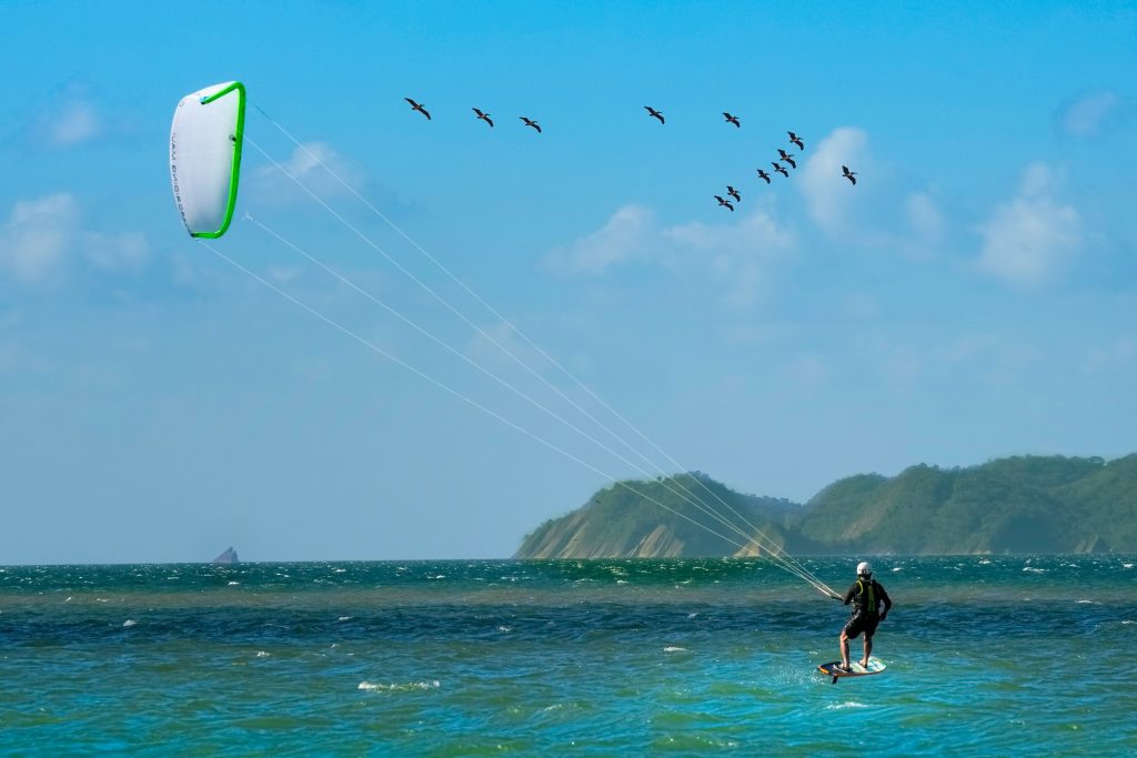A kite acrobat rides the sea
