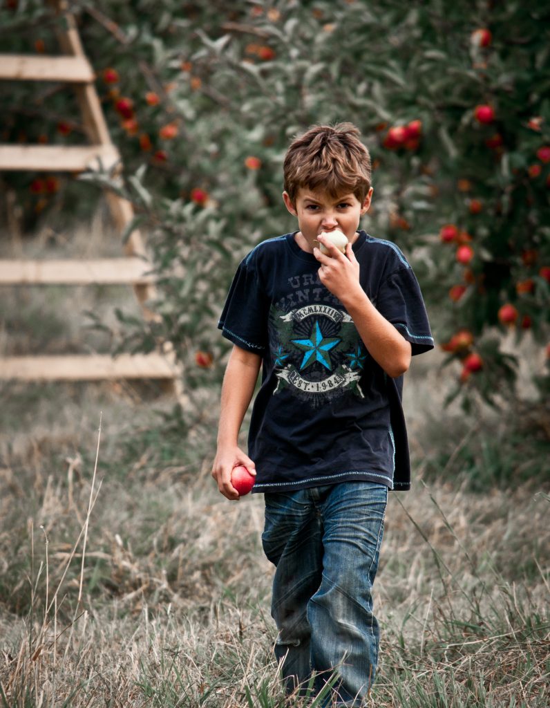 A your lad walks along munching an apple