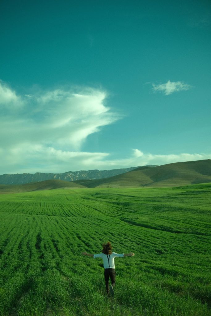 A figure runs across a field and simply enjoys being alive

